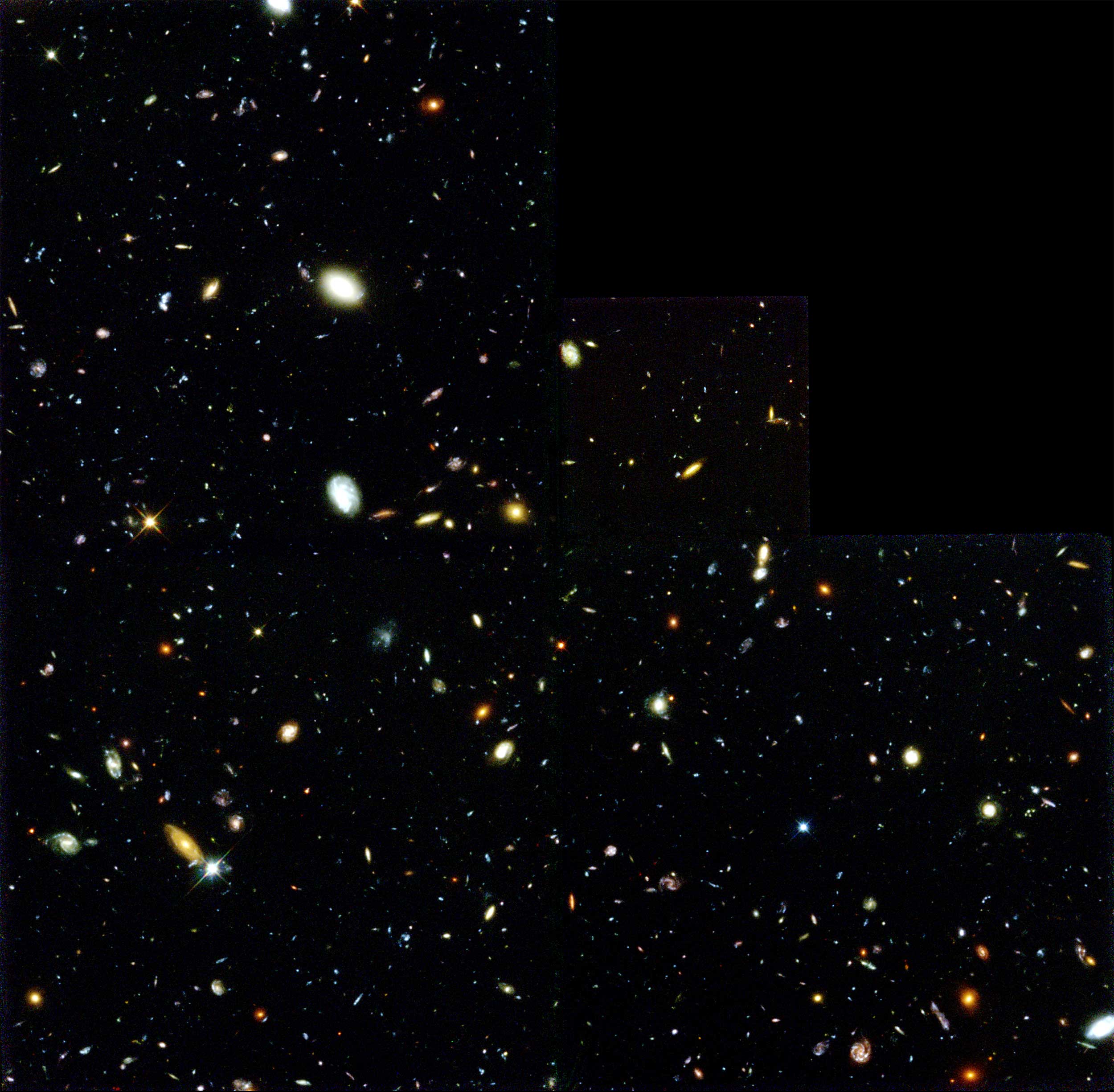 This image shows faraway galaxies as colorful dots in the black sky.