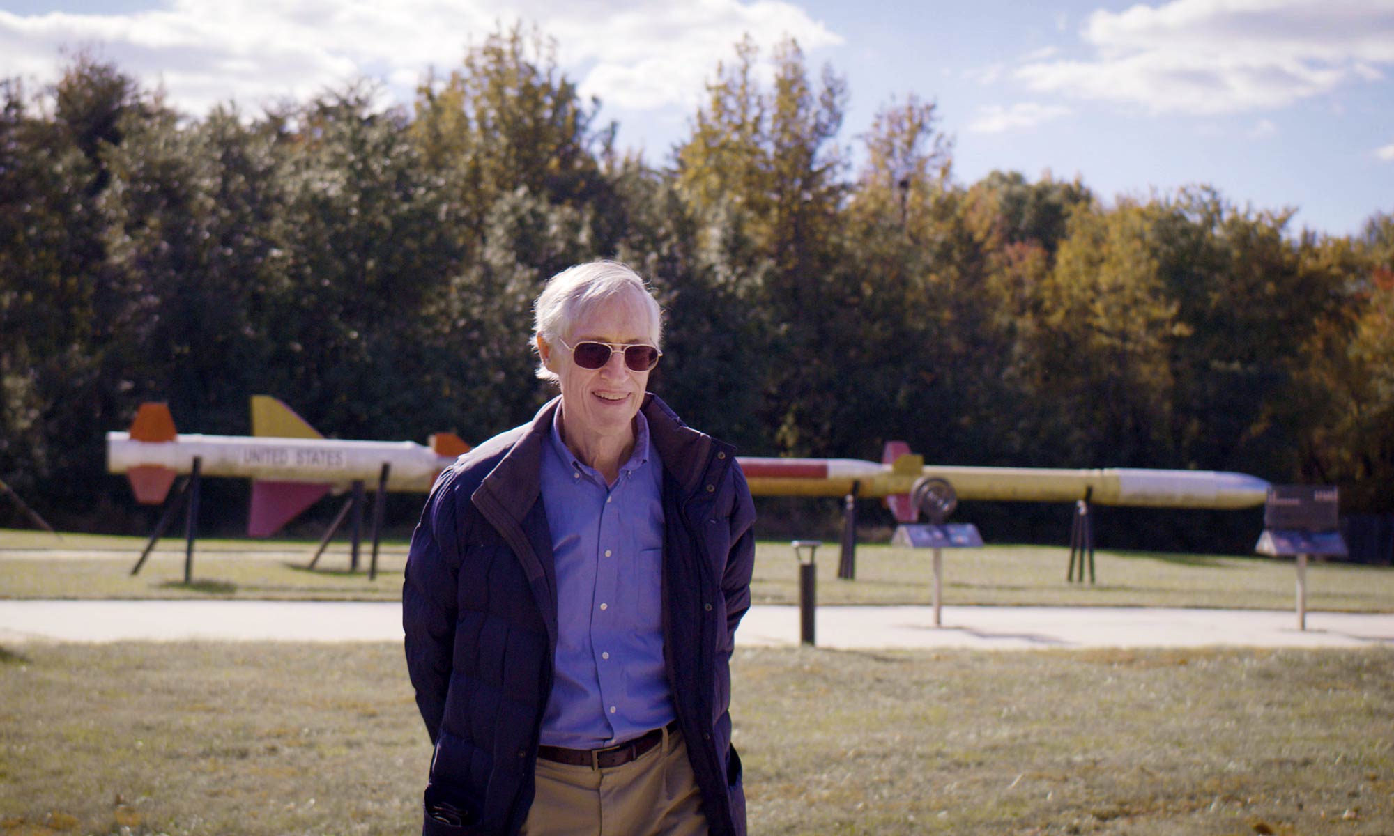 This photo shows John Mather standing in front of rockets at the space flight center.